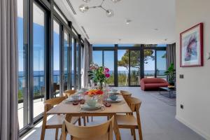 a dining room with a table and chairs and windows at Kuk Oaza Luxury Villas in Makarska