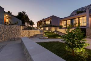 - un bâtiment avec un mur en pierre et des escaliers dans une cour dans l'établissement Kuk Oaza Luxury Villas, à Makarska