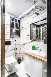 a bathroom with a sink and a toilet at Apartament Adasiowa Polana by Apart Concept Podhale in Kościelisko