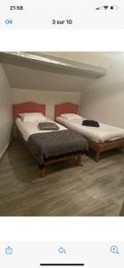 dos camas sentadas una al lado de la otra en una habitación en Le bonheur du Bengal, en Beauvais
