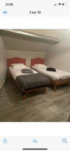 two beds sitting next to each other in a room at Le bonheur du Bengal in Beauvais