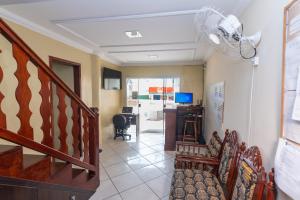 einen Flur mit einer Treppe und ein Zimmer mit einem Schreibtisch in der Unterkunft Dona Rosa Suites Privativas in Arraial do Cabo