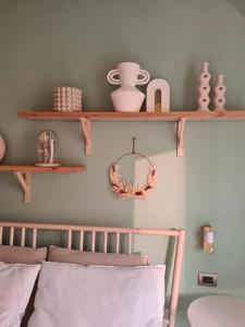 La Boheme Self check-in Suite في سان بيليغرينو تيرمي: غرفة نوم مع رفوف خشبية على الحائط