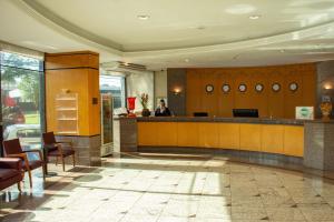 a lobby with a person sitting at a bar at Hotel Golden Park Internacional Foz & Convenções in Foz do Iguaçu