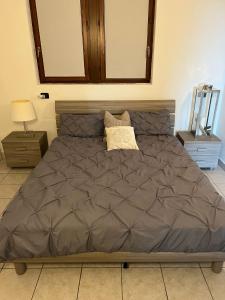 ein Schlafzimmer mit einem großen Bett mit einer braunen Decke in der Unterkunft LakeView LakeComo 4Seasons, Terrace, 30m to Lake! by STAYHERE-LAKECOMO in Acquaseria
