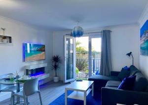 a living room with a couch and a table at Oceano - Carbis bay, St Ives, 1 bed apartment with free parking near to the beach in St Ives