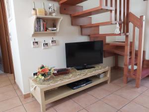 a television on a table in a living room at Snowflake Apartment in Campo di Giove