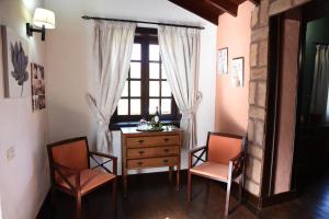 een kamer met 2 stoelen, een dressoir en een raam bij Hotel Rural Finca La Hacienda in Los Silos