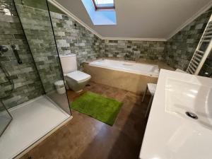 La salle de bains est pourvue d'une baignoire, de toilettes et d'une douche. dans l'établissement A Marola By Oktheway, à Pontedeume