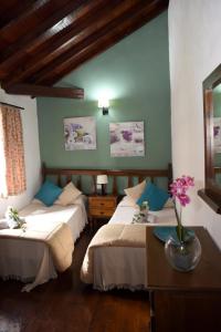 - une chambre avec 2 lits et une table fleurie dans l'établissement Hotel Rural Finca La Hacienda, à Los Silos