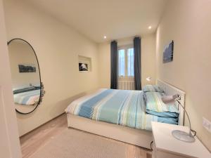 a small bedroom with a bed and a mirror at Lo Stellario di Lucca in Lucca