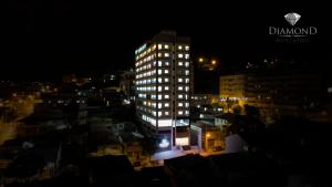 a tall building at night with lights on at Diamond Hotéis e Flats in São Lourenço