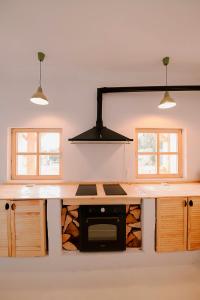 una cucina con piano di lavoro e piano cottura forno superiore di The Origin ● Mountain Guesthouse ● Magura a Măgura