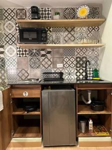 a kitchen with a stainless steel refrigerator and tiles at Inmueble cerca al estadio NID204 By Roots Rentals in Medellín