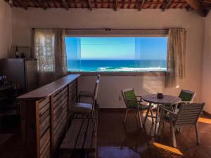 cocina con mesa y vistas al océano en Casa Sustentável em Figueira, Arraial do Cabo, en Arraial do Cabo