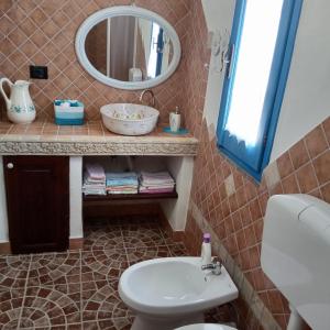 La salle de bains est pourvue d'un lavabo et d'un miroir. dans l'établissement Casa di Campagna, à Galtellì