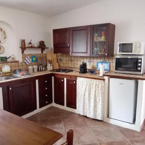 - une cuisine avec des placards en bois et un comptoir dans l'établissement Casa di Campagna, à Galtellì