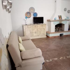 - un salon avec un canapé et une cheminée dans l'établissement Casa di Campagna, à Galtellì