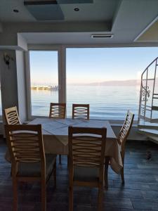 a dining room with a table and chairs and a large window at Hotel Restaurant Savoja in Pogradec