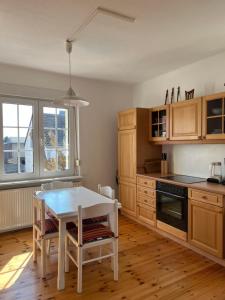 a kitchen with wooden cabinets and a table with chairs at Westfälischer Hof - 2nd floor 