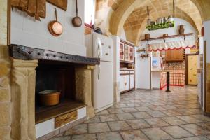 a kitchen with a stone fireplace in a room at Casa vacanza Il Giglio in Manduria