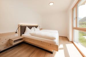 1 dormitorio con cama y ventana grande en Natur Suite Edelweisshof App Heidi, en Chiusa