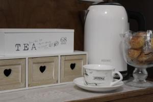 una mesa con una taza de café y una botella de té en Chez Les Sœurs, en Pompeya