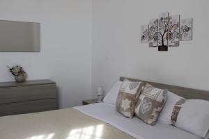 Dormitorio blanco con cama con almohadas en Chez Les Sœurs, en Pompeya