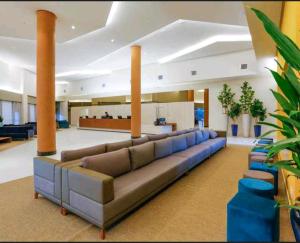 un ampio soggiorno con un grande divano in un edificio di Olímpia Park Resort-frente Thermas Laranjais-apt 5 p a Olímpia
