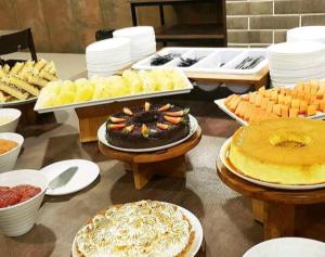 una mesa con muchos tipos diferentes de comida en ella en Olímpia Park Resort-frente Thermas Laranjais-apt 5 p en Olímpia