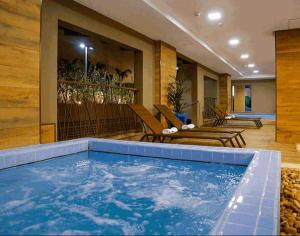 a swimming pool in a hotel with lounge chairs at Olímpia Park Resort-frente Thermas Laranjais-apt 5 p in Olímpia +3 photos