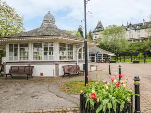 a building with benches and flowers in front of it at Otter Lodge in Strathpeffer