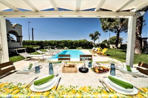 een tafel met borden eten naast een zwembad bij Villa Vespucci in Torricella