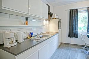 a kitchen with white cabinets and a sink at Stettiner Haff Nebengebäude in Mönkebude