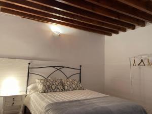 1 dormitorio con cama y techo de madera en Al-Mansur en Granada