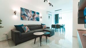 a living room with a couch and a table at Beachside Stylish & Cosy 2BR Apartment with Free Parking in Sliema