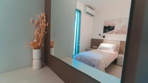 a reflection of a bedroom with a bed in a mirror at Beachside Stylish & Cosy 2BR Apartment with Free Parking in Sliema