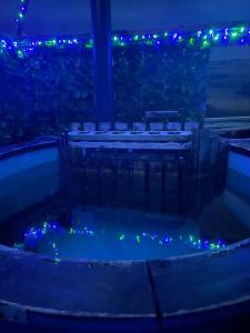 a hot tub with blue and green lights at night at Croft B&B Accommodation With Hot Tub in Gamrie
