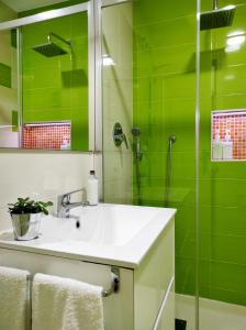 グラナダにあるApartamentos Centro CasaBellaの緑豊かなバスルーム(シンク、シャワー付)