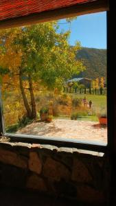 a window view of a field with a tree at El Mirador Casas de Montaña in Potrerillos