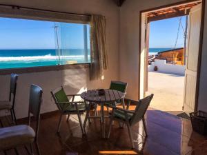 comedor con mesa y sillas y vistas al océano en Casa Sustentável em Figueira, Arraial do Cabo, en Arraial do Cabo