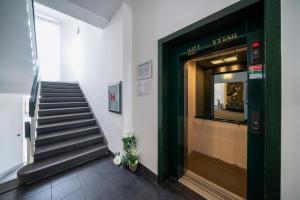 a hallway with a staircase and a green door at Penzion Homer Poděbrady in Poděbrady