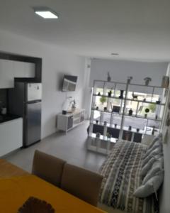 Una sala de estar con una mesa y una cocina. en Monoambiente frente al río en Ramallo, en Ramallo