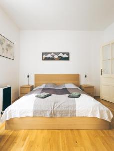 a bedroom with a large bed with a wooden headboard at Oltec Apartment Brno in Brno