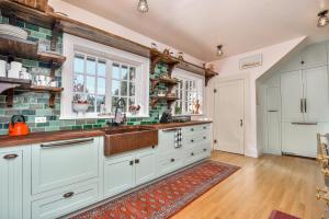 Metaline FallsにあるThe Rock House of Metaline Fallsの白いキャビネットとカウンタートップを備えたキッチン