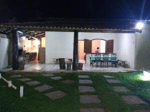 a patio with a table and chairs at night at Casa das orquídeas in Santana do Riacho
