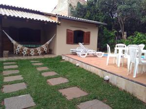 a patio with chairs and a hammock next to a house at Casa das orquídeas in Santana do Riacho
