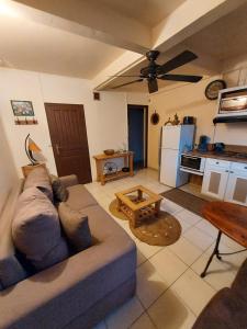 ein Wohnzimmer mit einem Sofa und einer Küche in der Unterkunft Résidence les 2 MONTOUT in Le Gosier