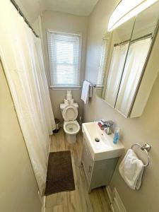 a bathroom with a toilet and a sink and a mirror at Hamilton Mountain Plaza - King Bed - Free Parking in Hamilton