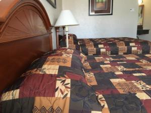 a bedroom with a bed with a quilt on it at Landmark Motor Inn in Glens Falls